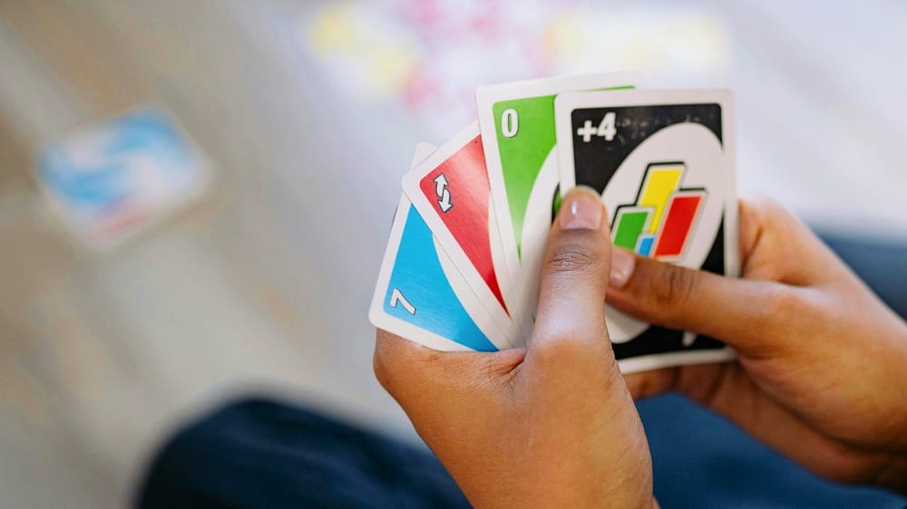 A photo of someone holding 4 Uno cards in their hands