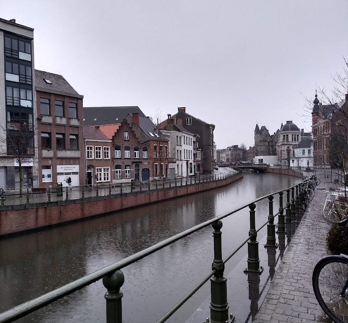 Picture of Ghent canal with bikes lining the railings on a grey cloudy day
