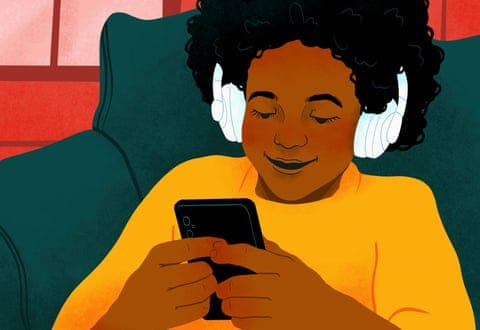 Smiling girl with headphones and smart phone playing video game