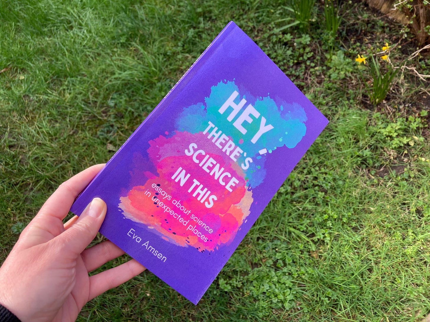Hey, There's Science In This. Purple book being held above grass