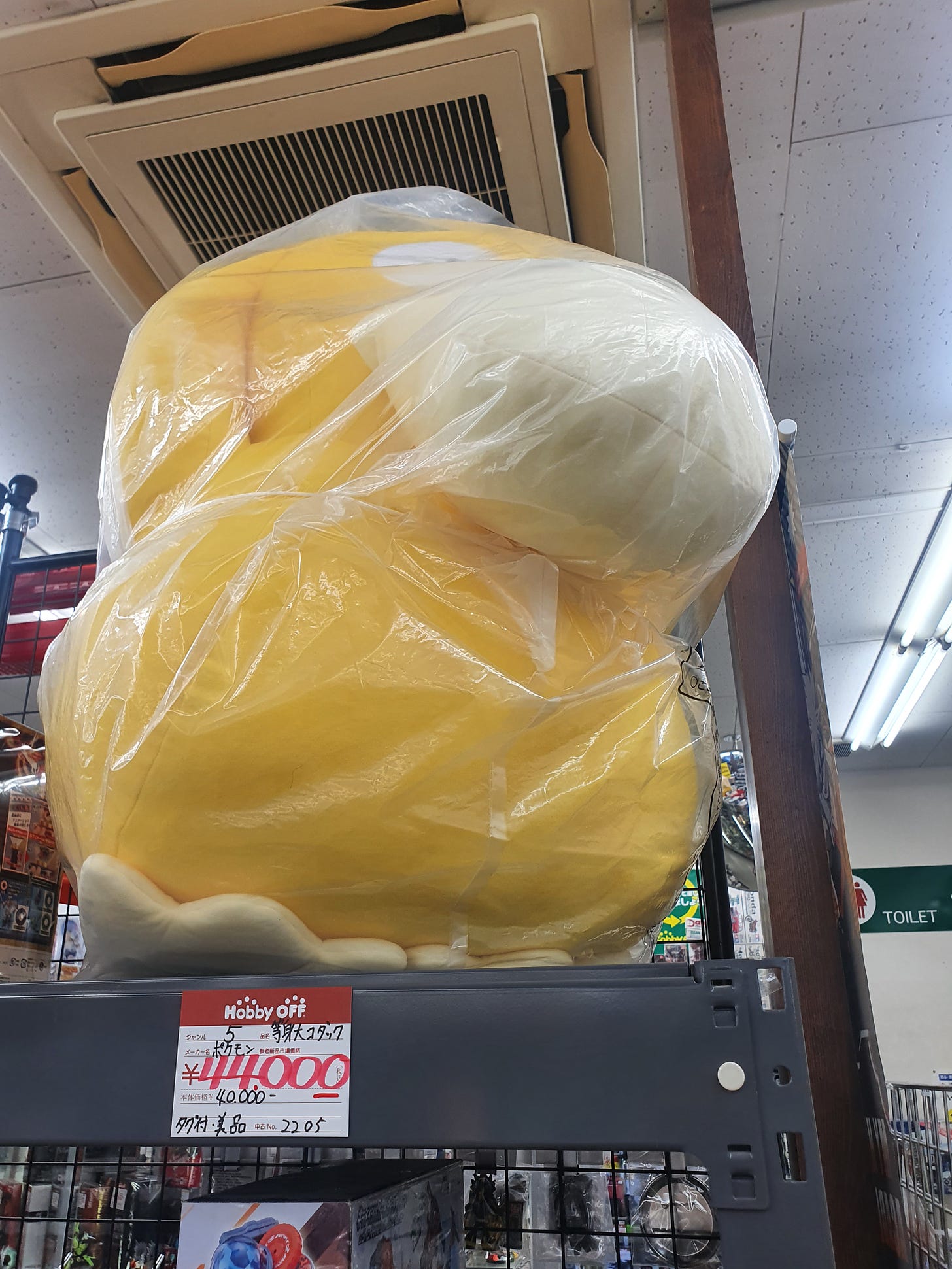 A gigantic Psyduck plush toy, wrapped in its original packaging. Set him free!