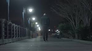 Man walking down a city street at night