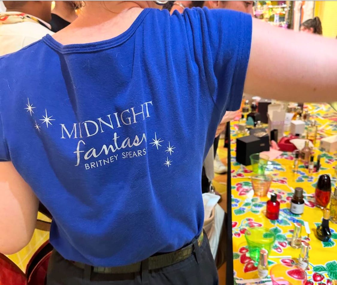 the back of a blue tee shirt that says "Midnight Fantasy Britney Spears"