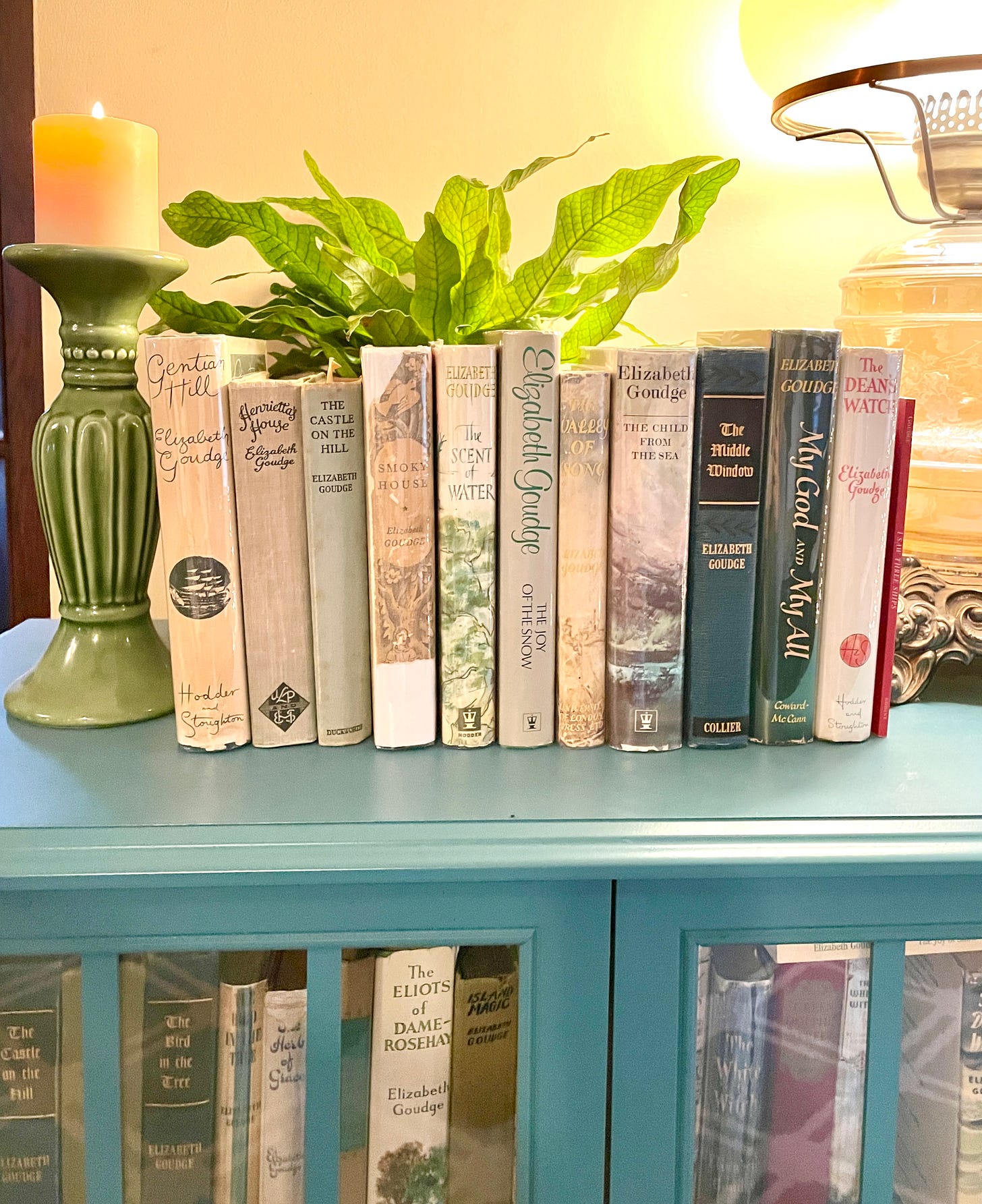 My Goudge bookcase with our Goudge Readalong 2025 books lined up on top.