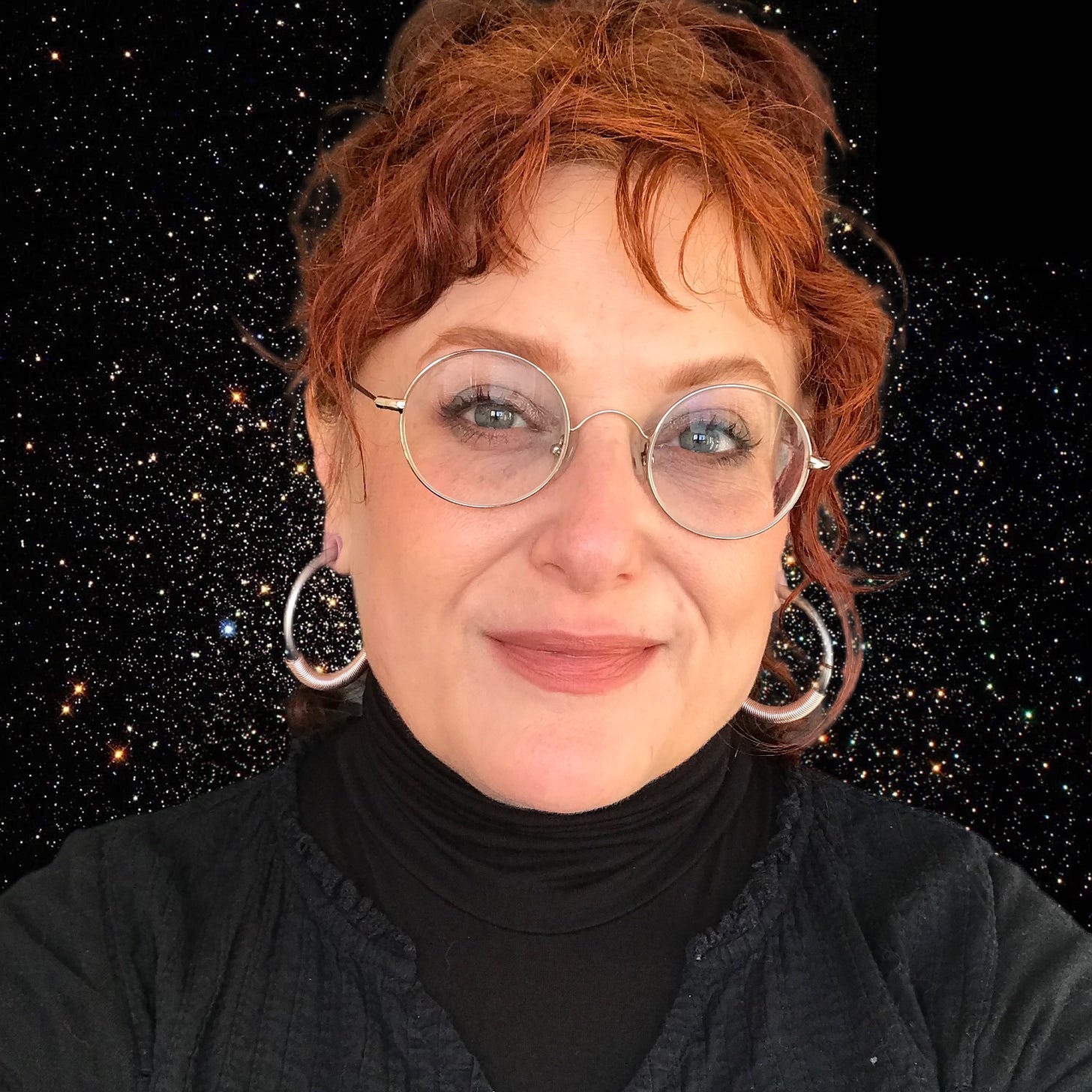 A red haired, middle aged woman with her hair up. She is smiling and wears round silver glasses and big hoop earrings. The background has been removed and there is a black sky with stars behind her. 