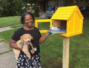 Kathy Henderson stands next to a Little Free Library in Highland Park, Michigan. Photo: Detroit Little Libraries