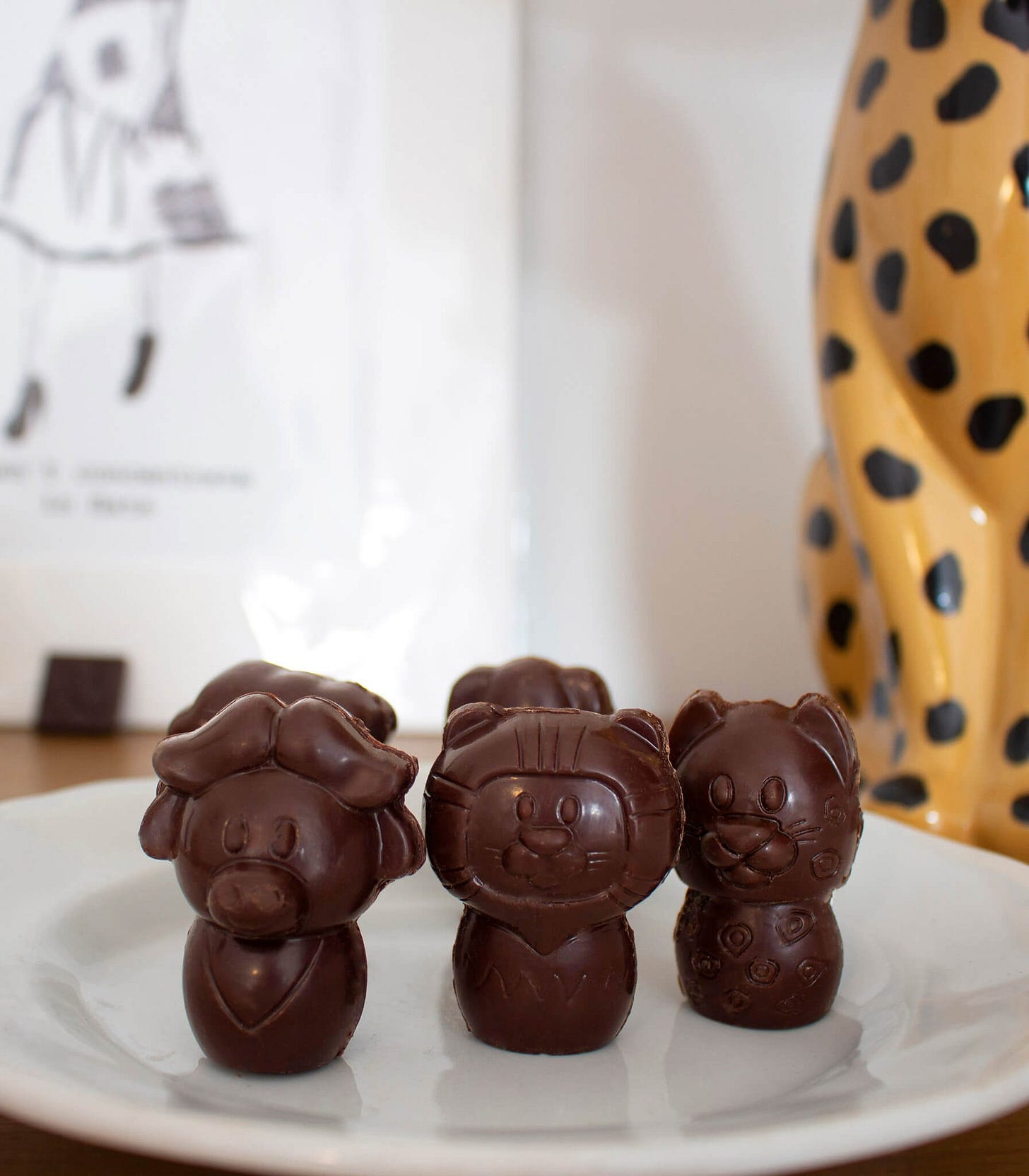 figures in dark chocolate shaped like wild animals in cute cartoon style, on white plate