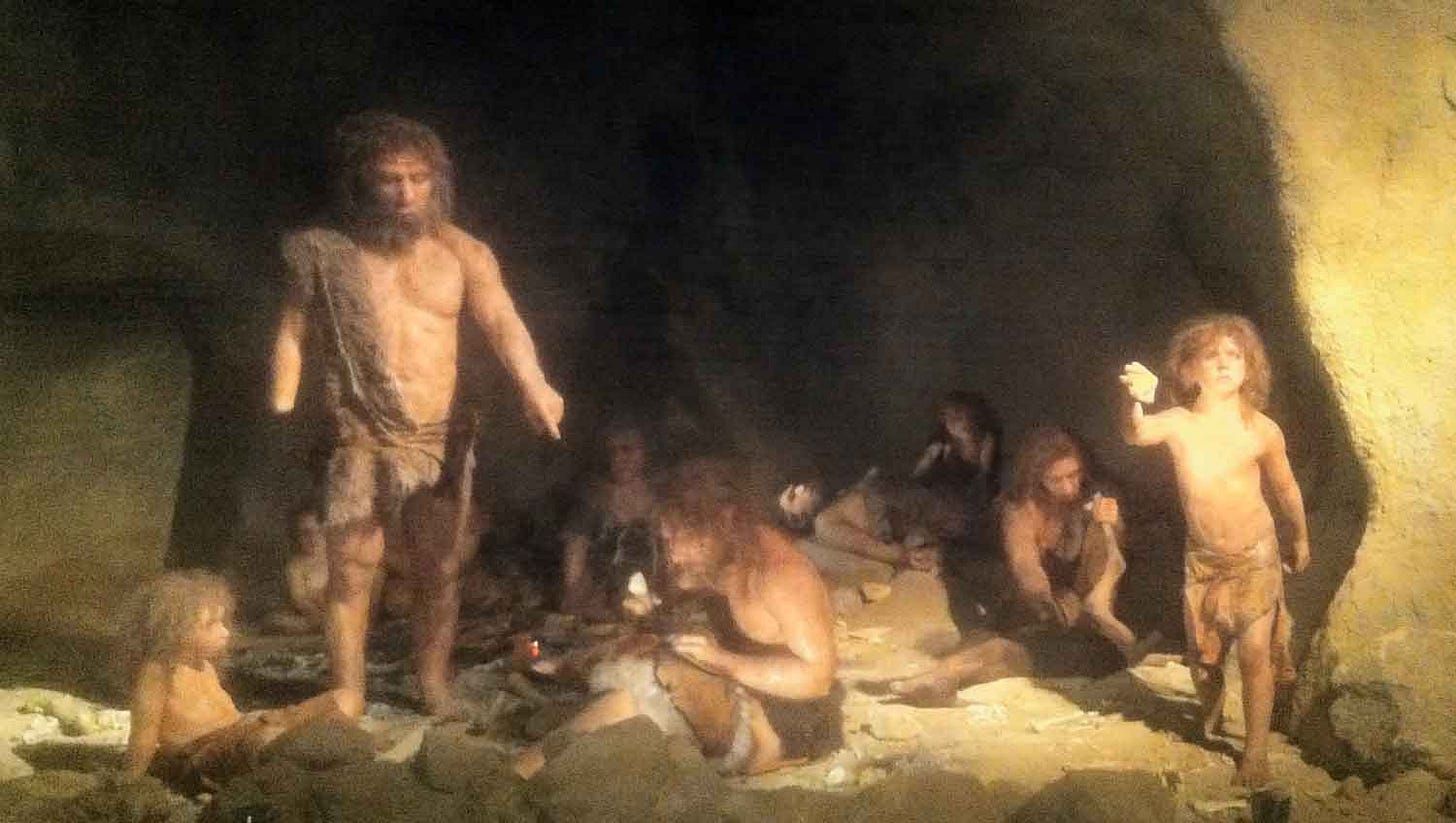 A group of Neandertals in a rockshelter with firelight A group of Neandertals in a rockshelter with firelight