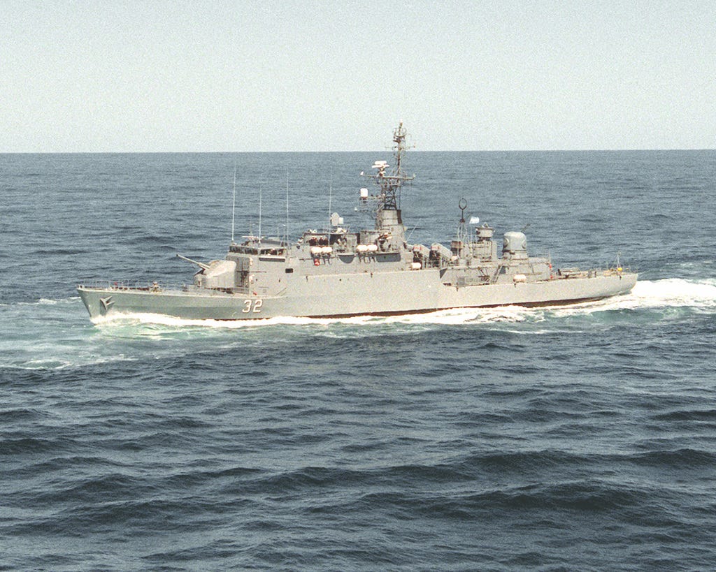 A small grey ship on a large grey ocean. The sky is also grey.