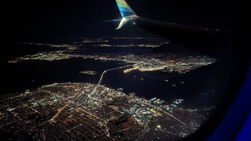 Photo taken out the window of a plane flying over San Francisco at night on the way to SFO airport