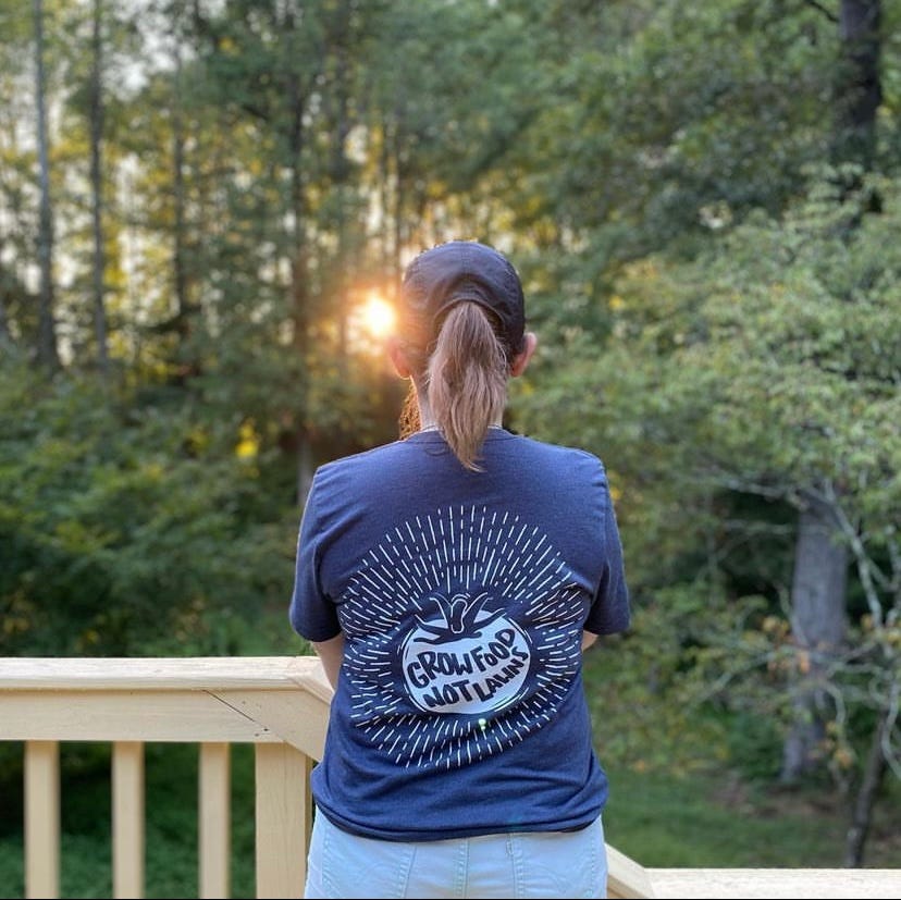 person facing away with a shirt that says "Food Not Lawns"