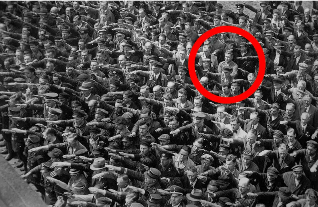 There is a famous black-and-white photograph from the era of the Third  Reich. It is a picture taken in Hamburg, Germany, in 1936, of shipyard  workers, a hundred or more, facing the