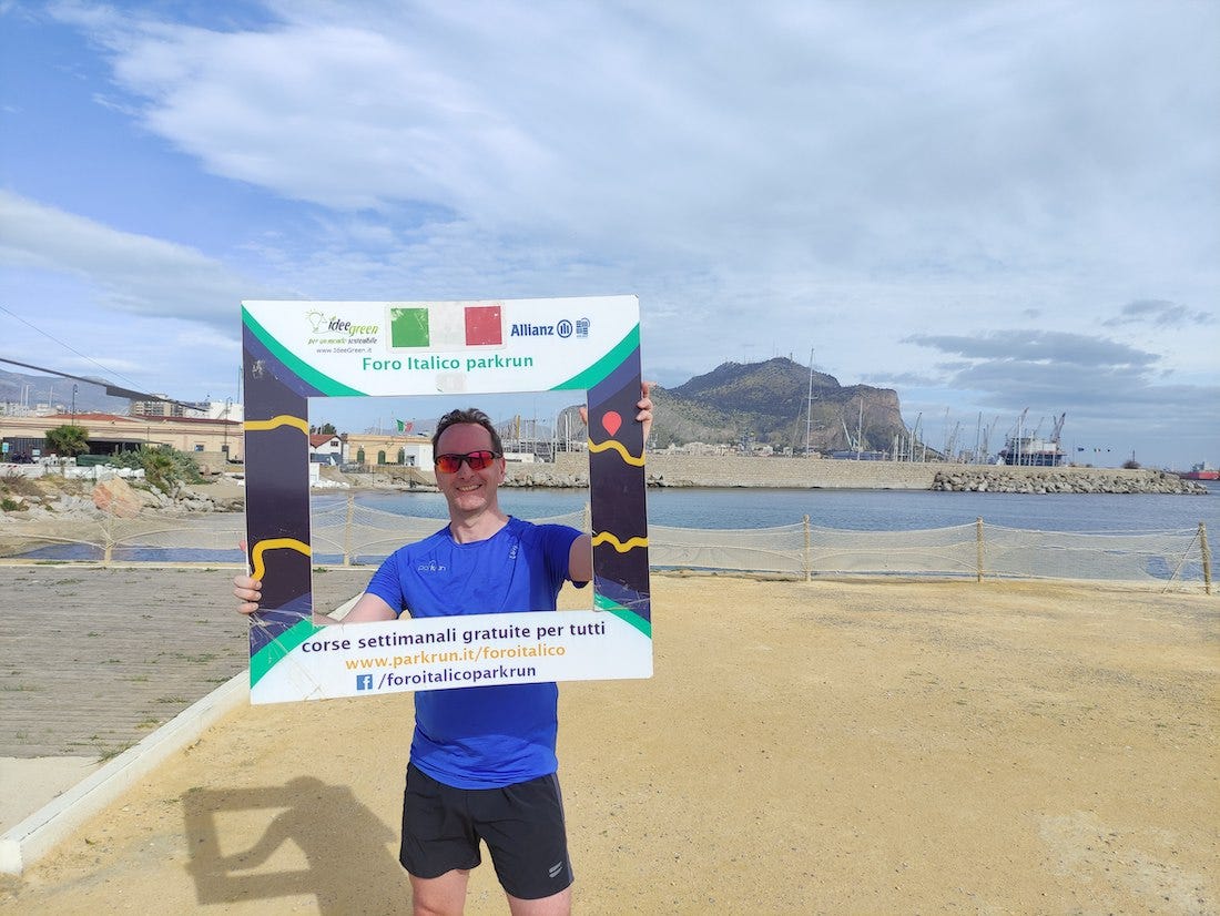 Me in a parkrun selfie frame, with the port and rock behind