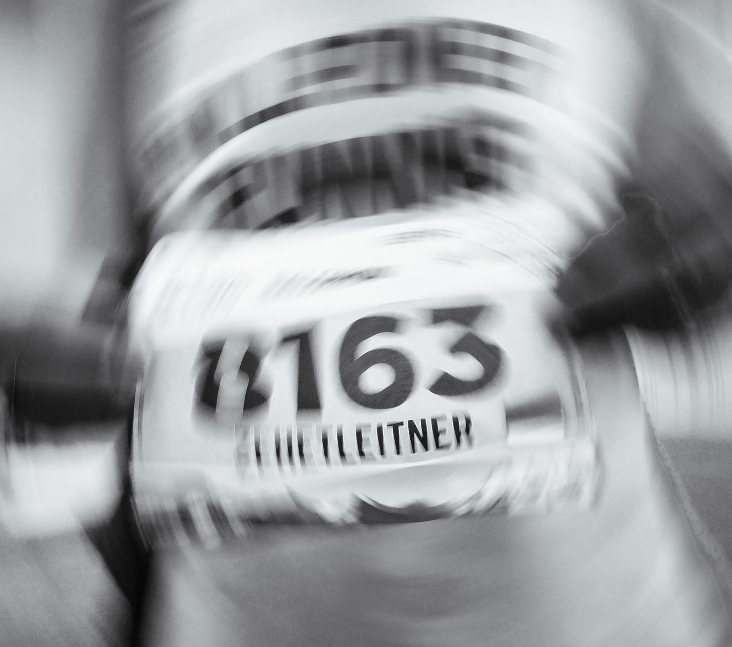 The author holding a bib number into the camera, blurry picture