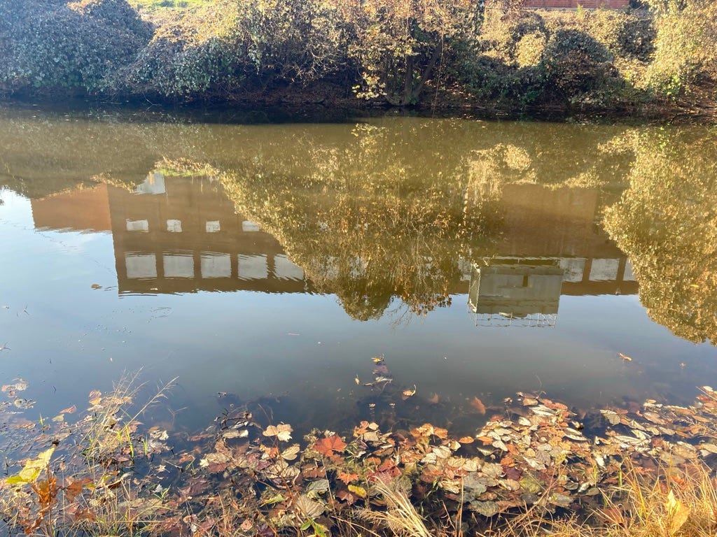 abandoned textile mill, reflected in still river
