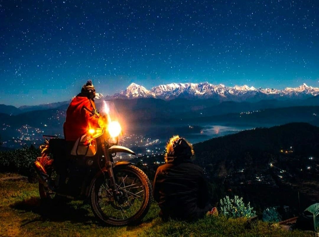 Two people sitting on a motorcycle at night