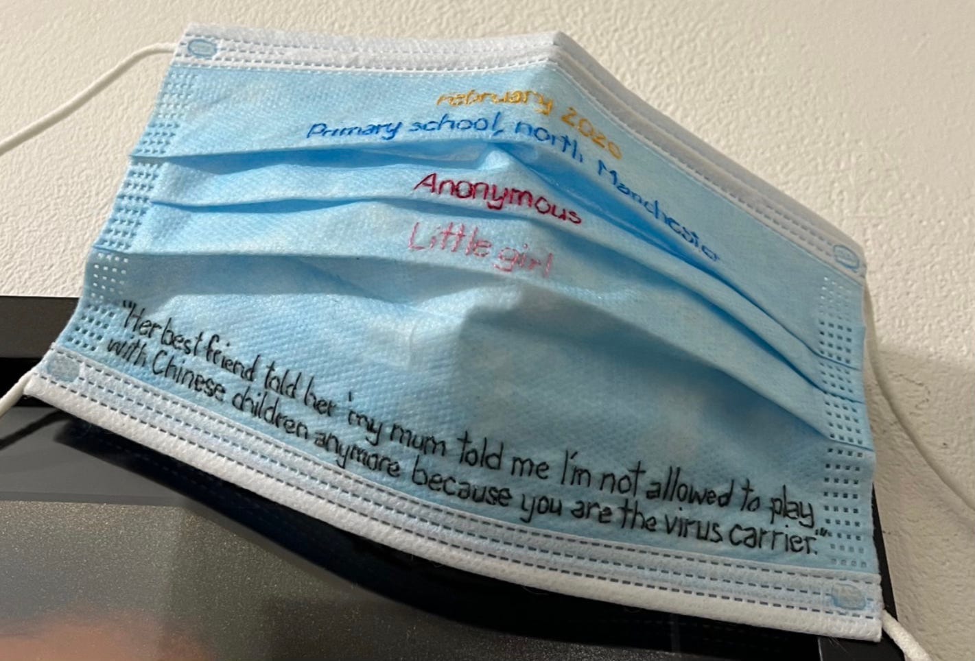 A face mask with writing on it

AI-generated content may be incorrect.