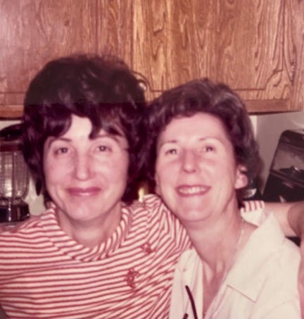 Two smiling dark-haired middle-aged women. 