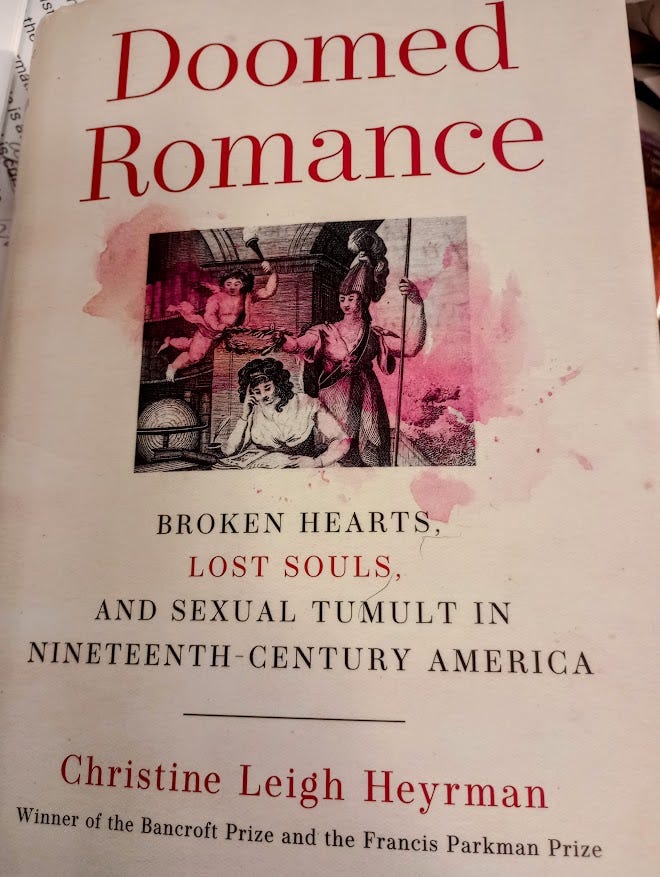 Cover of Doomed Romance, with drawing of young woman reading a book, while an angel holds a light over here, and I think it's Lady Liberty holds a kind of garland crown over her head