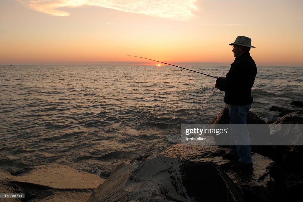 Silhouette of a fisherman during sunrise on Lake Michigan