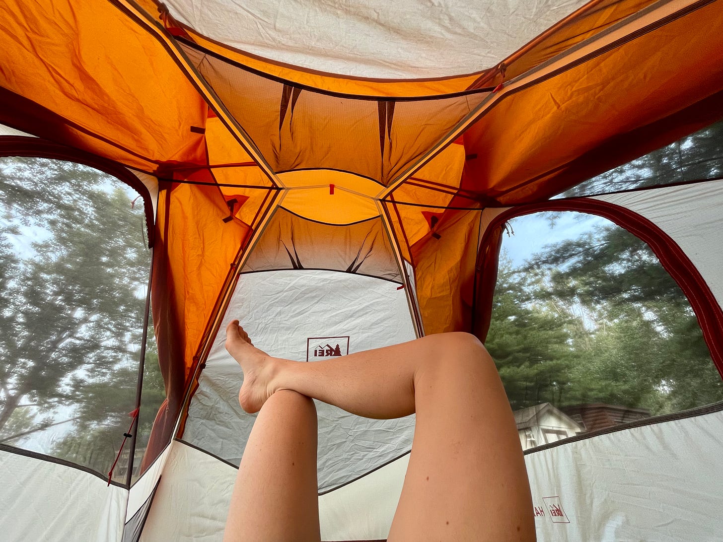 Photograph of the inside of a tent, with someone's legs visible.