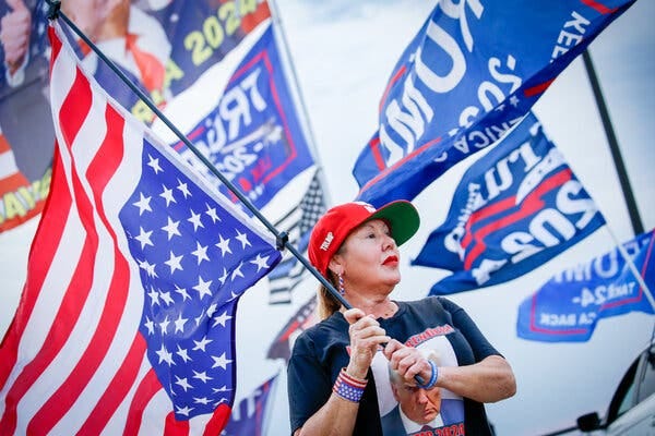 A supporter of former President Donald J. Trump holding an upside down flag.