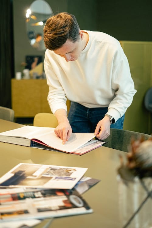 Free Man Pointing and Reading a Book Stock Photo