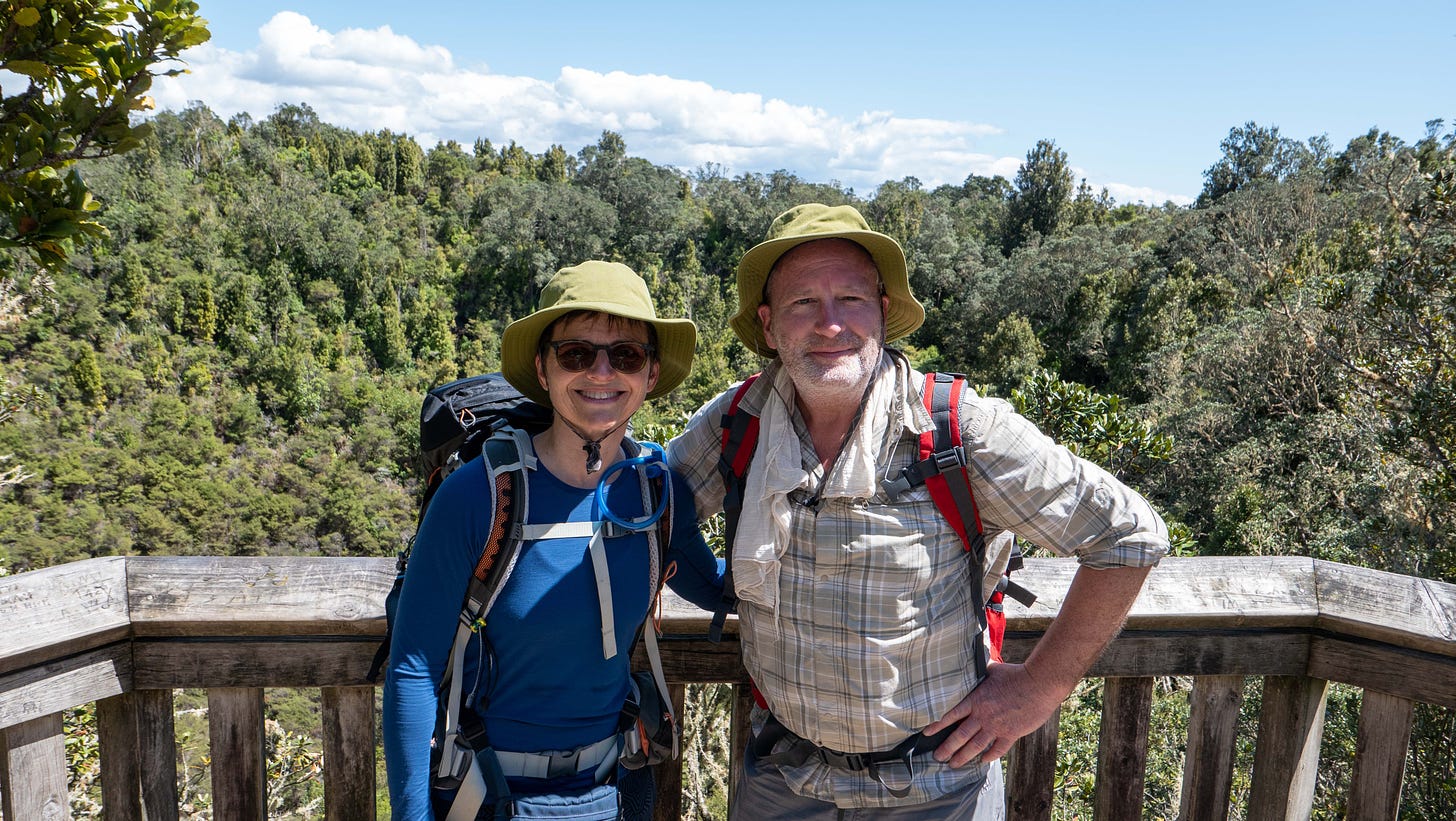 Julia and Mike in the sun, in front of Rangitoto's tree-lined crater.