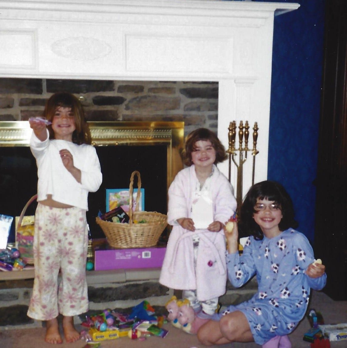 Three little girls in pajamas  delightedly show off what the Easter Bunny left in their baskets