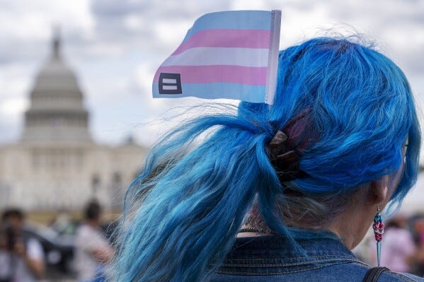 With the Capitol in the background, Kali wears a trans equality flag in her hair while attending a rally for the Trans Day of Visibility, on the National Mall, Monday, March 31, 2025, in Washington."I'm here because I'm trans and it's a day to be visible," she said, "our rights, everyone's rights, are under attack." (AP Photo/Jacquelyn Martin)