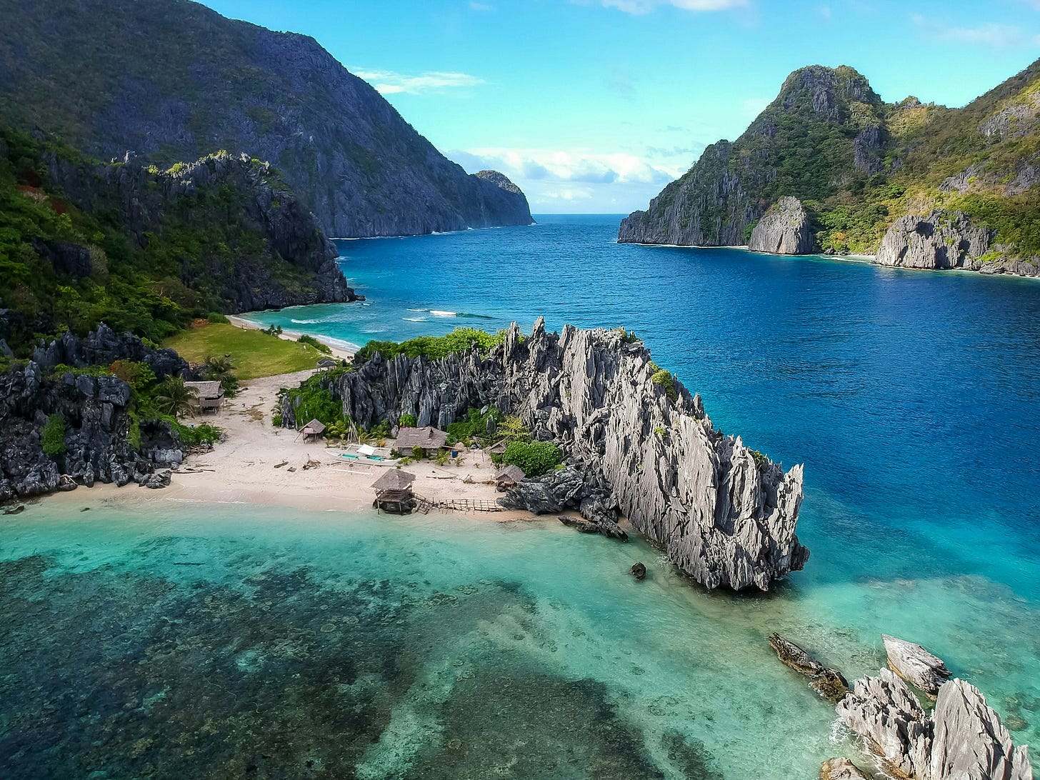 Rocky coastline with beach and blue water Rocky coastline with beach and blue water