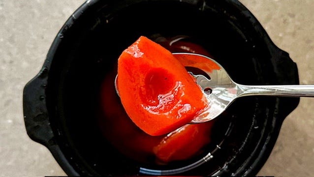 A quarter of bright pink poached quince in syrup.