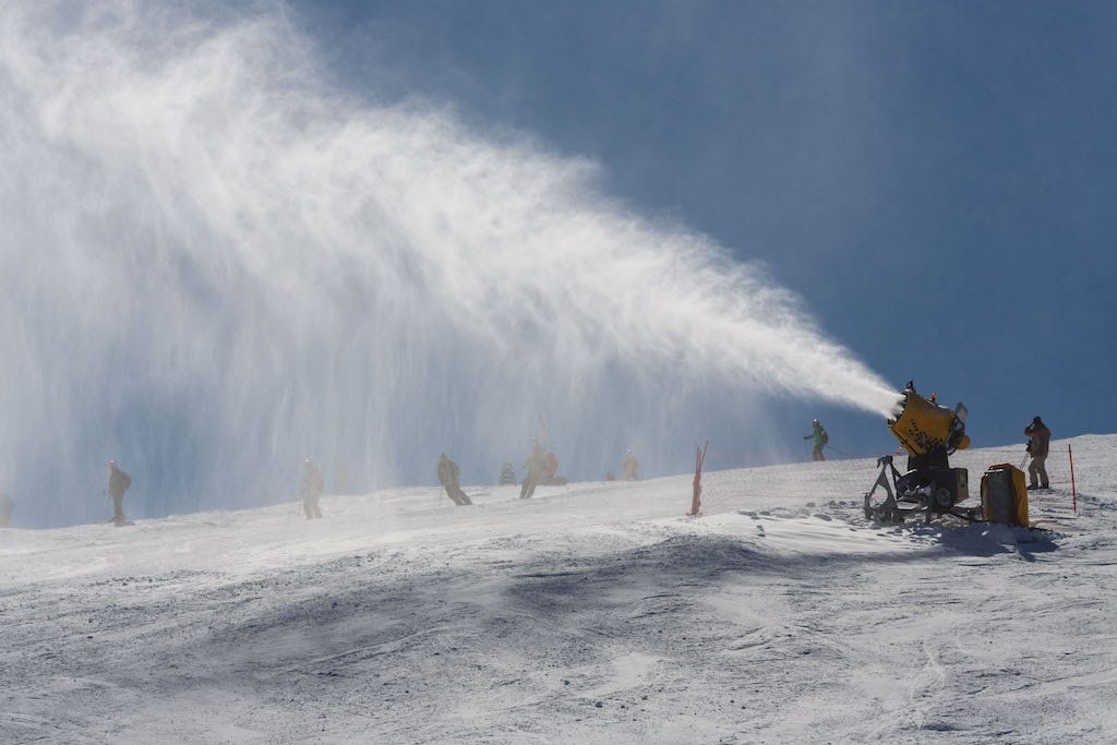 Snowmaker sprays snow on the piste for mountain skiers. 