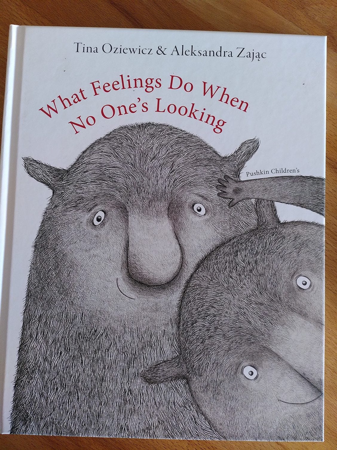 Hardback children's book cover, white background with drawings of 2 furry, friendly looking creatures that take up most of the space. Authors and Title are at top of cover.