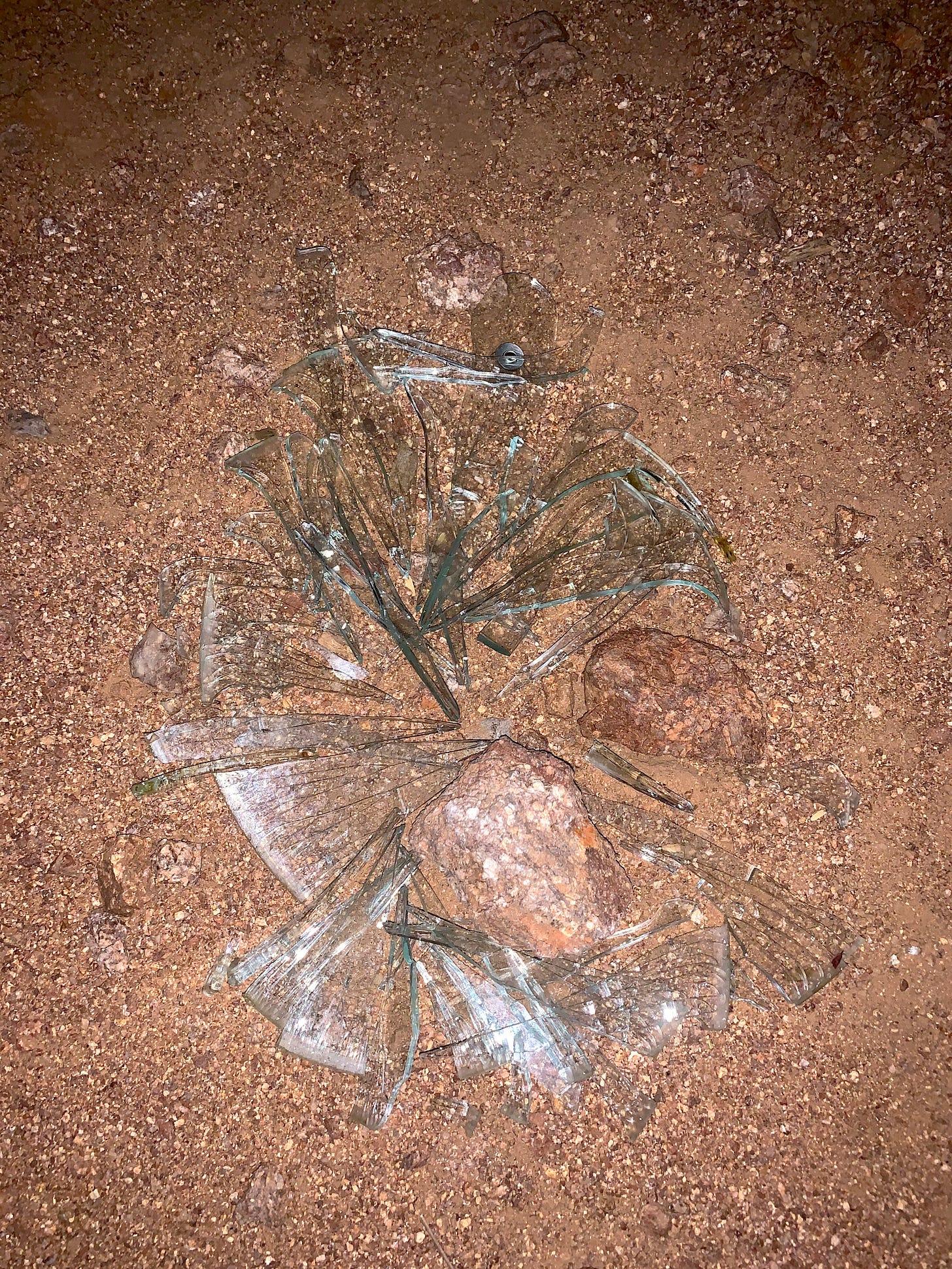 Broken glass in hard sand