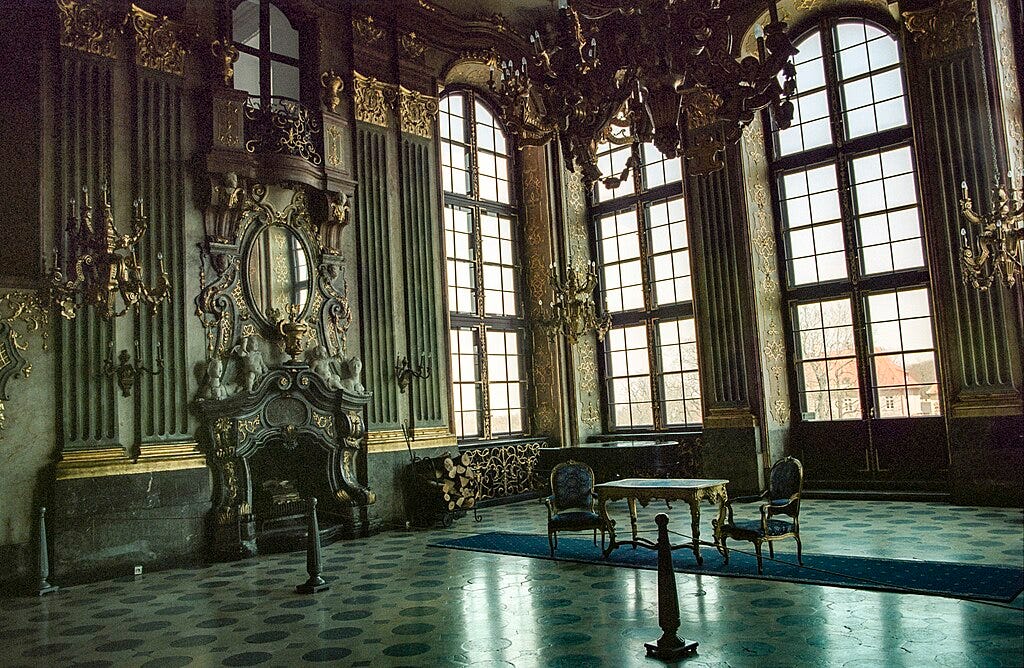 room with green wwalls and ornate gold chandeliers