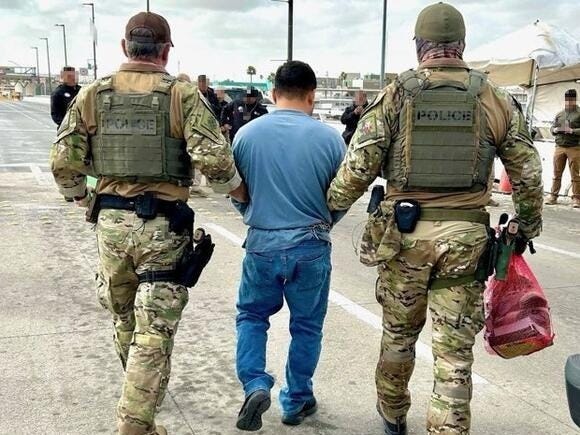 Immigration & Customs Enforcement Agents escort a man who crossed illegally into US to Mexican authorities who want him for a crime there. Immigration & Customs Enforcement Agents escort a man who crossed illegally into US to Mexican authorities who want him for a crime there.
