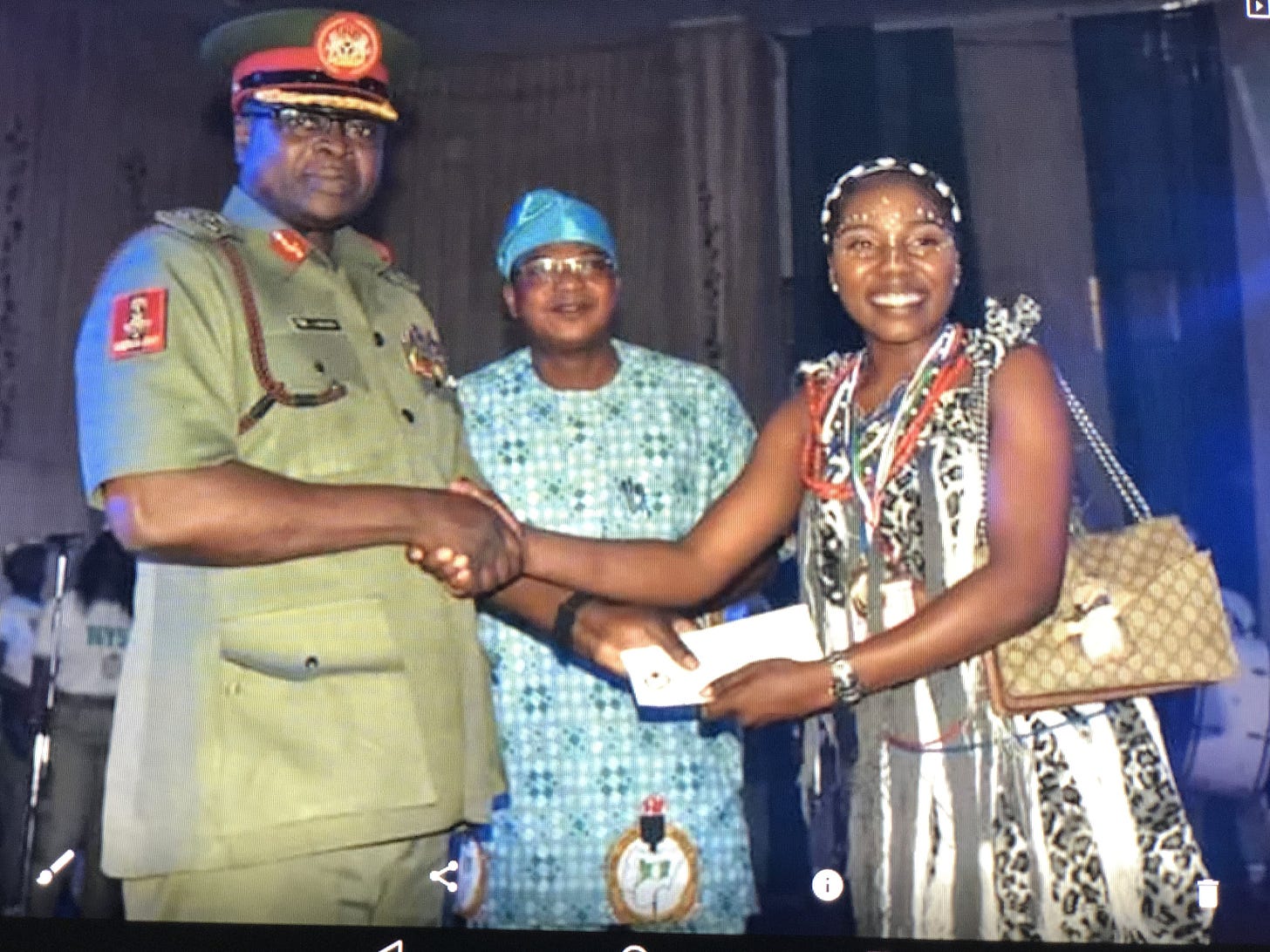A lady in traditional Plateau attire in a handshake with a Nigerian General