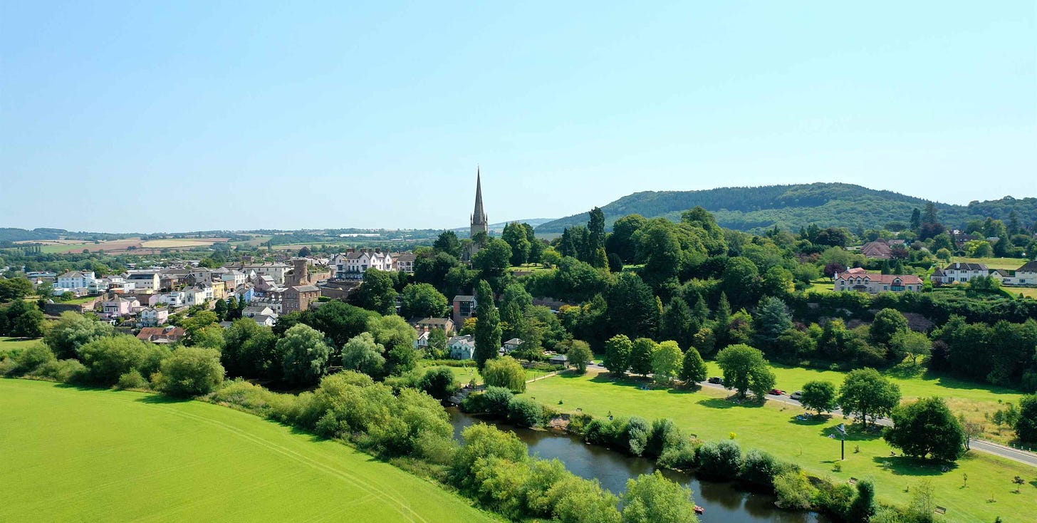 Green fields with a river, houses in the distance and a tall church spire - Ross-on-Wye