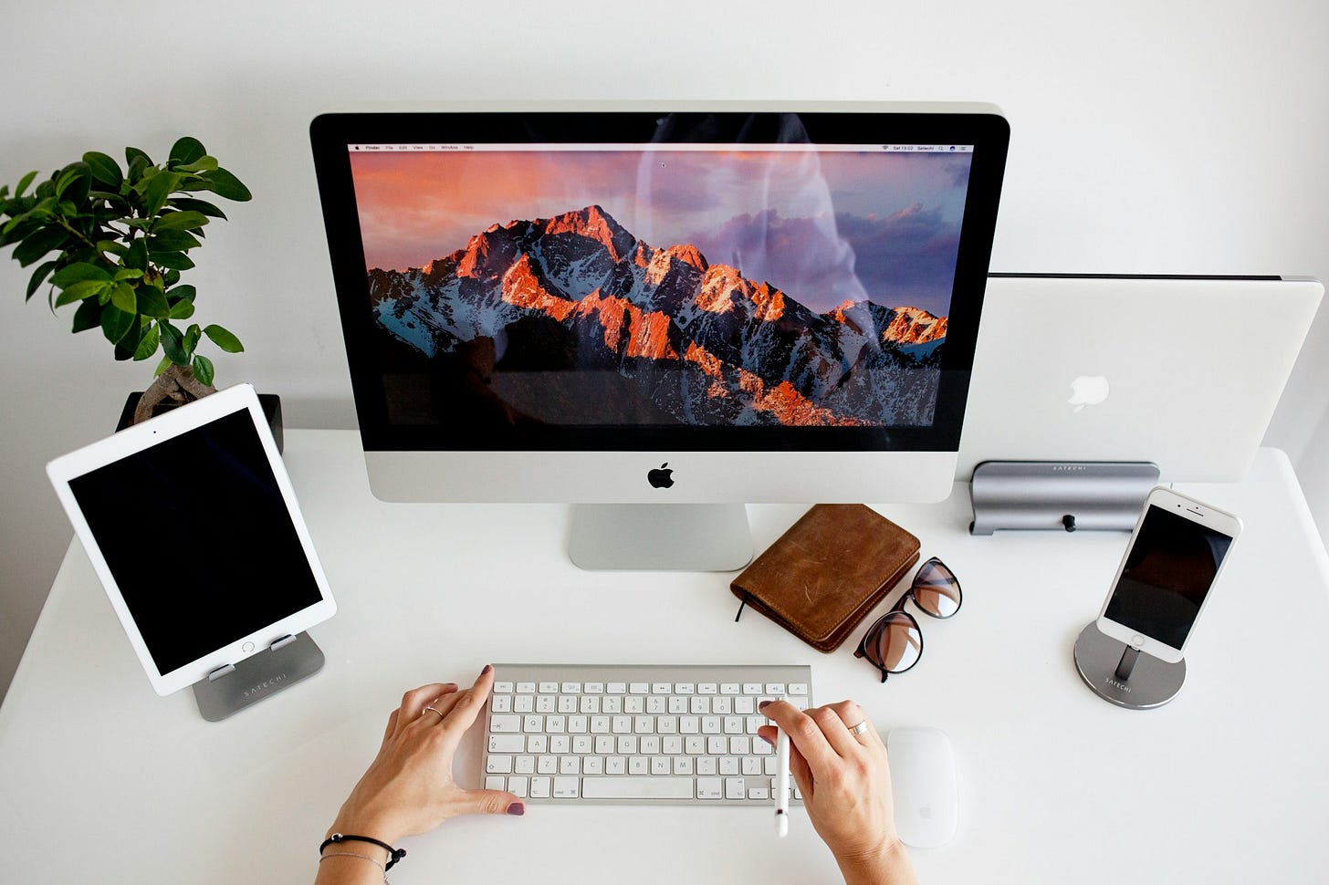 person using silver imac and apple magic keyboard person using silver imac and apple magic keyboard