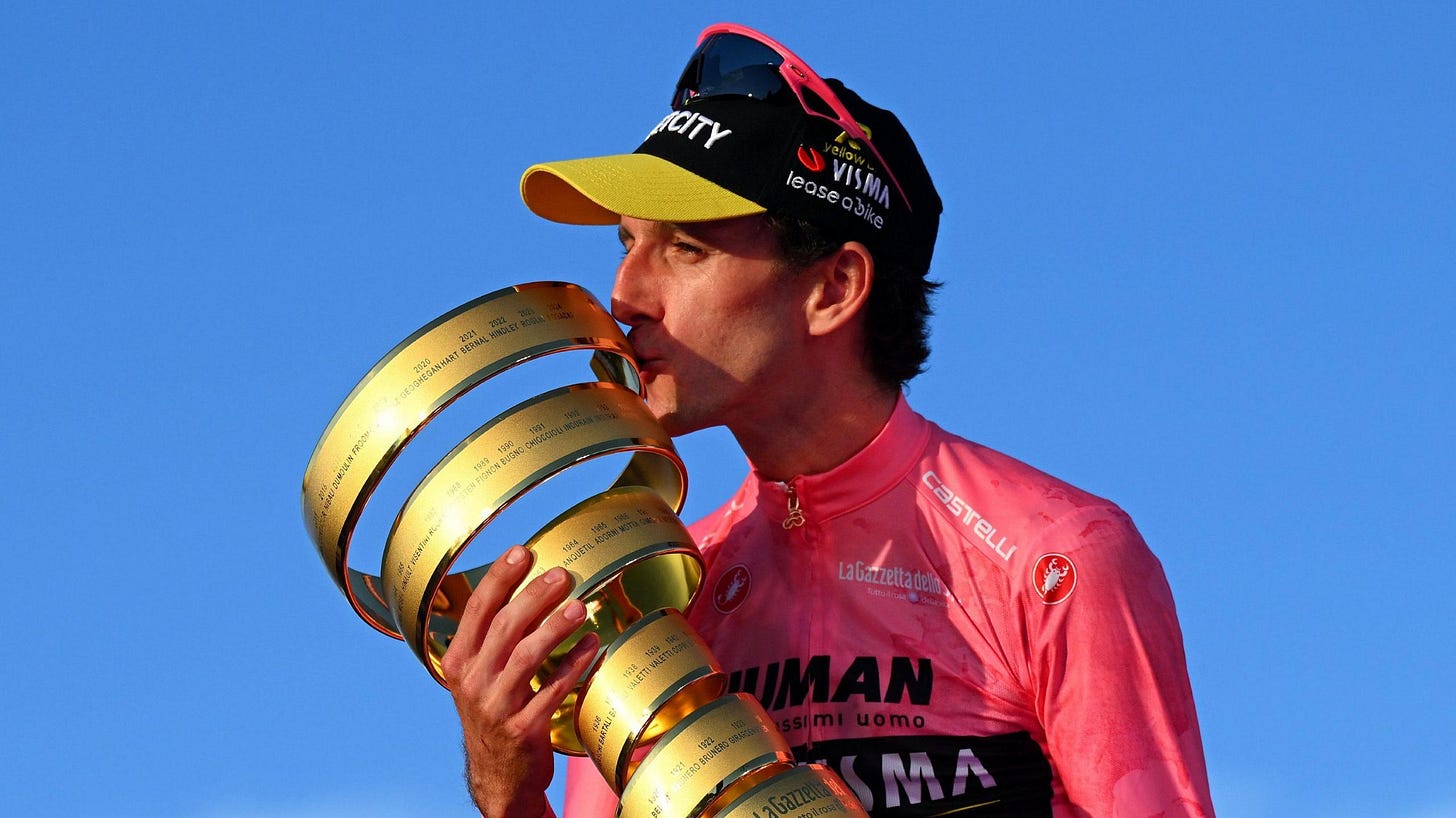 Simon Yates kisses the Giro d'Italia trophy while wearing the leader's pink jersey Simon Yates kisses the Giro d'Italia trophy while wearing the leader's pink jersey