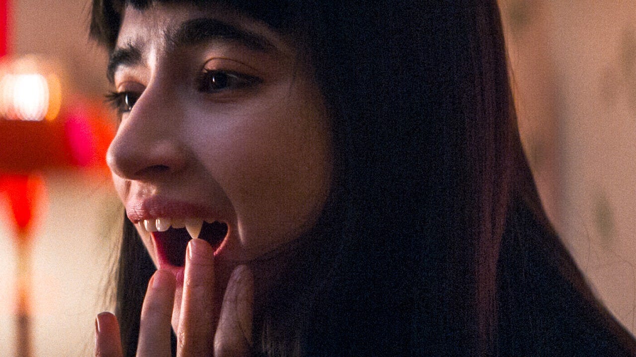 Movie still from Humanist Vampire Seeking Consenting Suicidal Person. A woman touches her sharp vampire fangs.