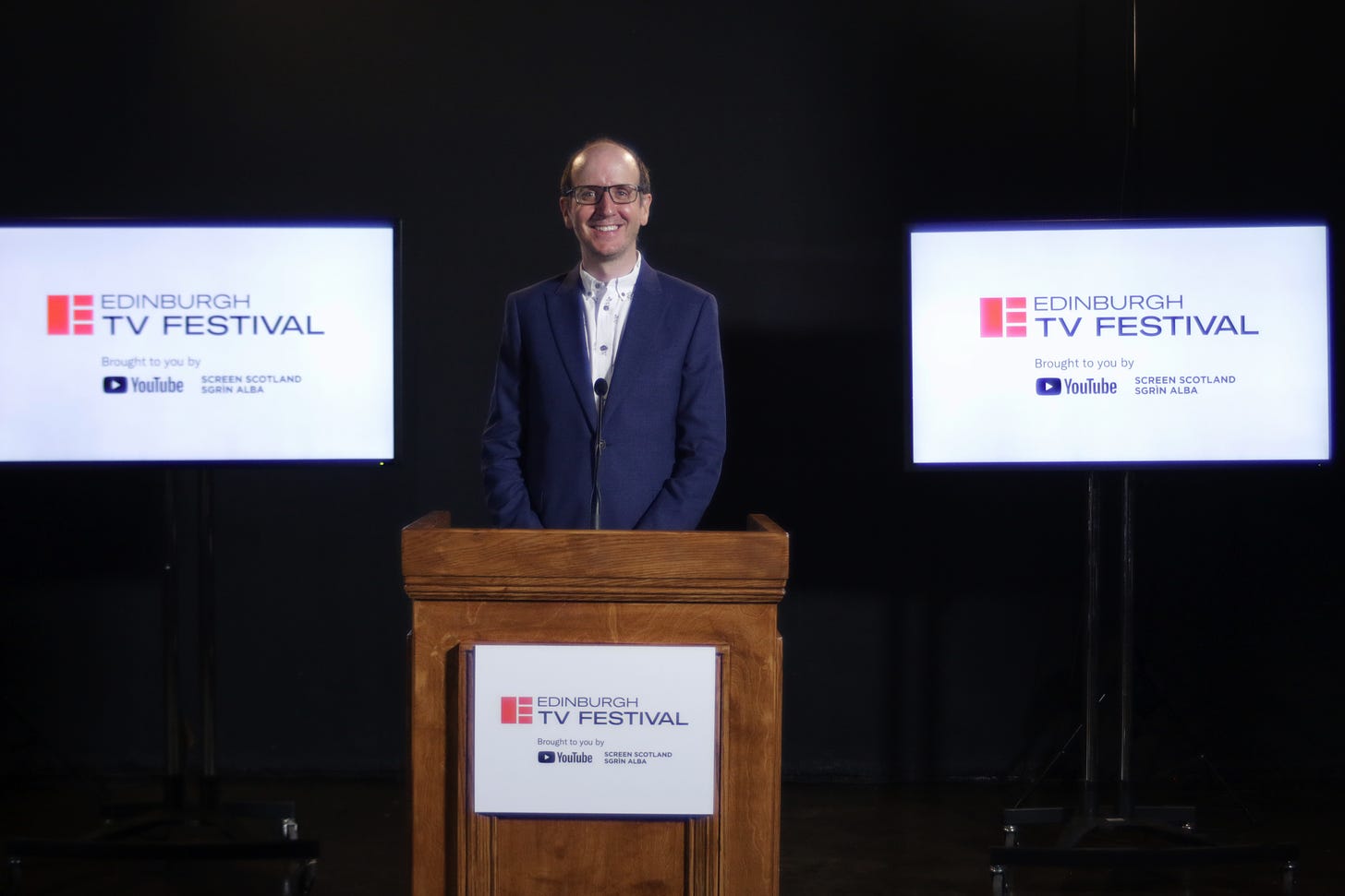 Jack Thorne standing behind a brown parapet at the Edinburgh TV Festival.