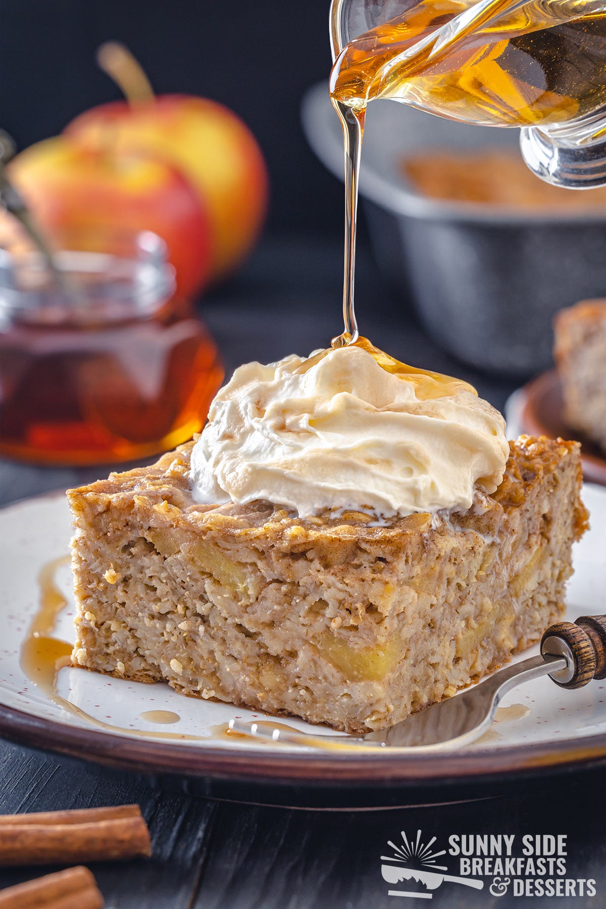 A slice of baked oatmeal with whipped cream and syrup.