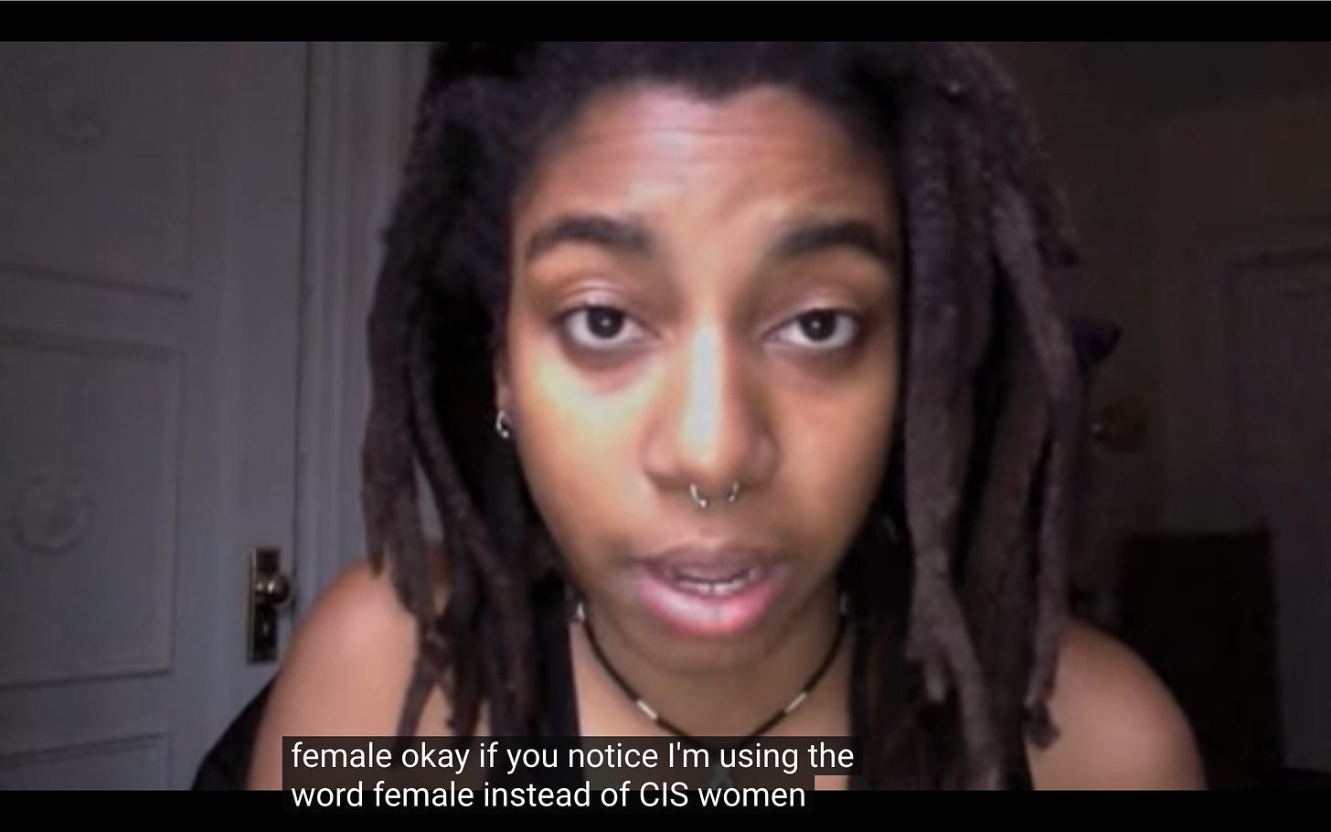 n3vlynnn speaking in front of the camera. the subtitle says "If you notice I'm using the word female instead of CIS women"