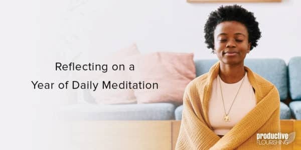 Black woman smiling, sitting in meditation with a mustard-yellow scarf around her. Text overlay: Reflecting on a Year of Daily Meditation