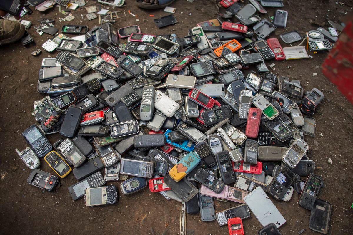 Pile of discarded mobile phones and smartphones in a landfill, to demonstrate the environmental cost of throwing away these devices