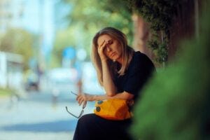 woman at bus stop looking overheated
