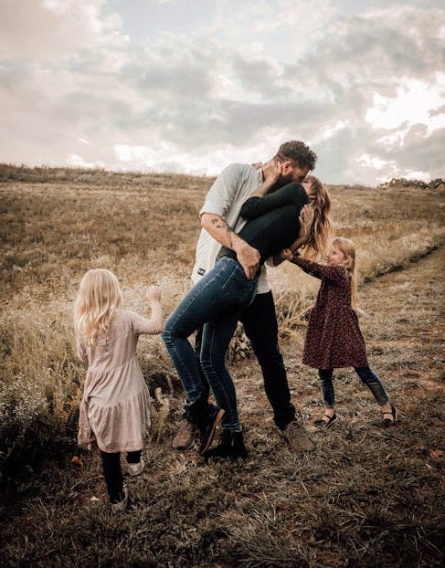 Free A joyful family shares a loving moment outdoors, surrounded by nature. Stock Photo