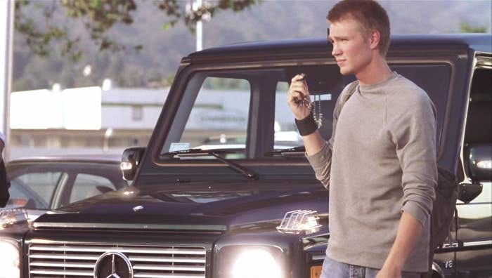 Still from A Cinderella Story showing Austin Ames (played by Chad Michael Murray) pressing his key fob to lock up his giant Mercedes that he just parked like a dick